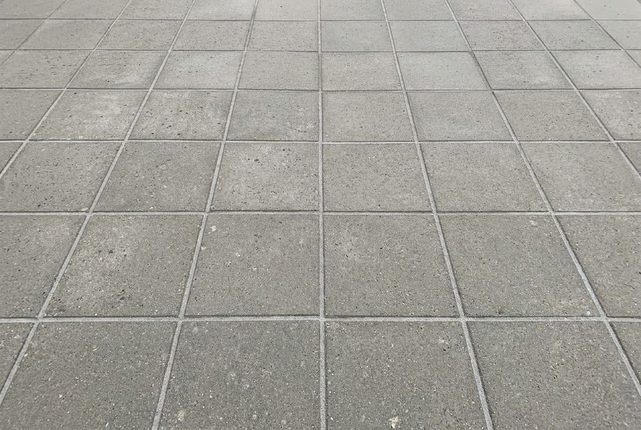Samme fliseterrasse efter rens, med ensartet grå overflade og nyt fugesand